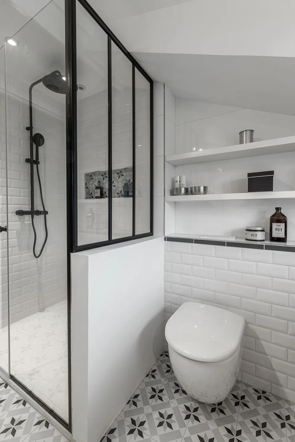 Studio Madame : architecte d’intérieur, Paris et Montmorency
Projet réalisé à Enghien-les-Bains.
Photographie d’intérieur : salle de bain aux tons noir et blanc avec verrière noire, carreaux de métro en faïence et carrelage imitation carreaux de ciment au sol.