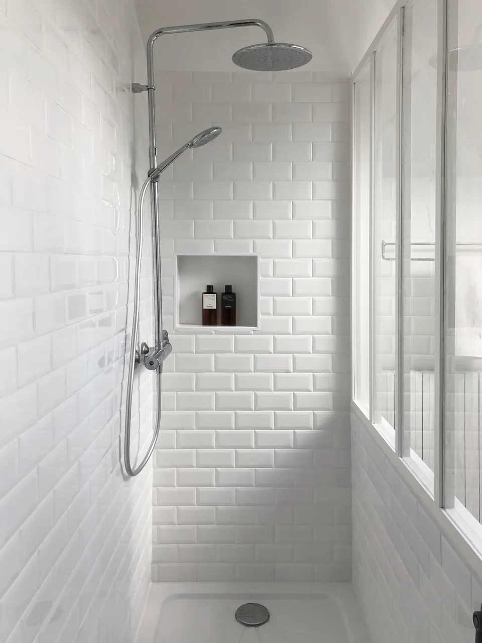 Studio Madame : architecte d’intérieur, Paris et Montmorency
Projet réalisé à Cormeilles-en-Parisis.
Photographie d’intérieur : salle de bain avec douche séparée par une verrière blanche, carreaux de métro en faïence, robinetterie chromée et niche carrée.