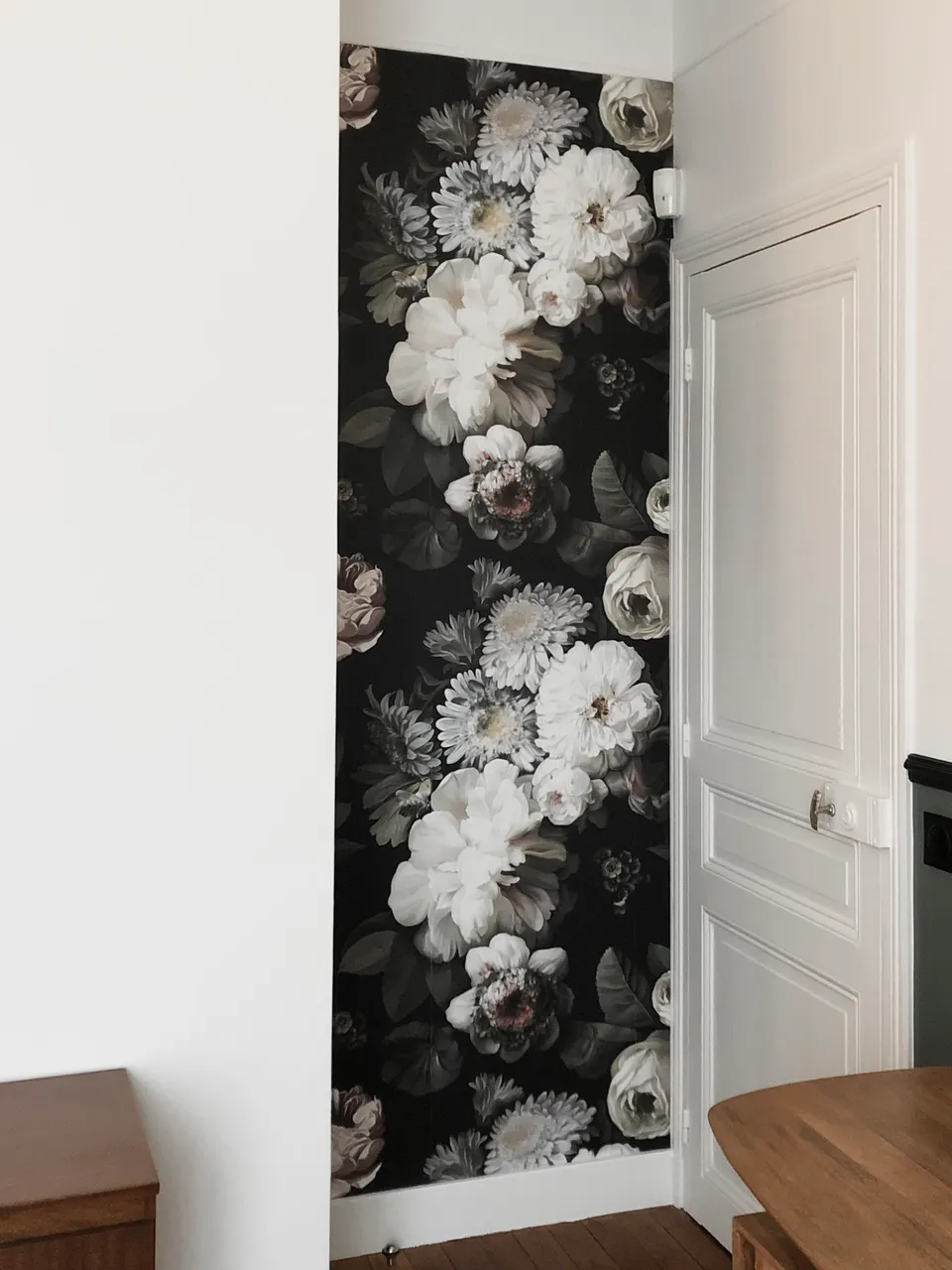 Studio Madame : architecte d’intérieur, Paris et Montmorency
Projet réalisé à Enghien-les-Bains.
Photographie d’intérieur : entrée de la pièce (bureau) mise en valeur par un papier peint foncé à fleurs en contraste avec l’autre mur blanc orné d’un soubassement vert foncé. Porte ancienne de type haussmannien, repeinte en blanc.