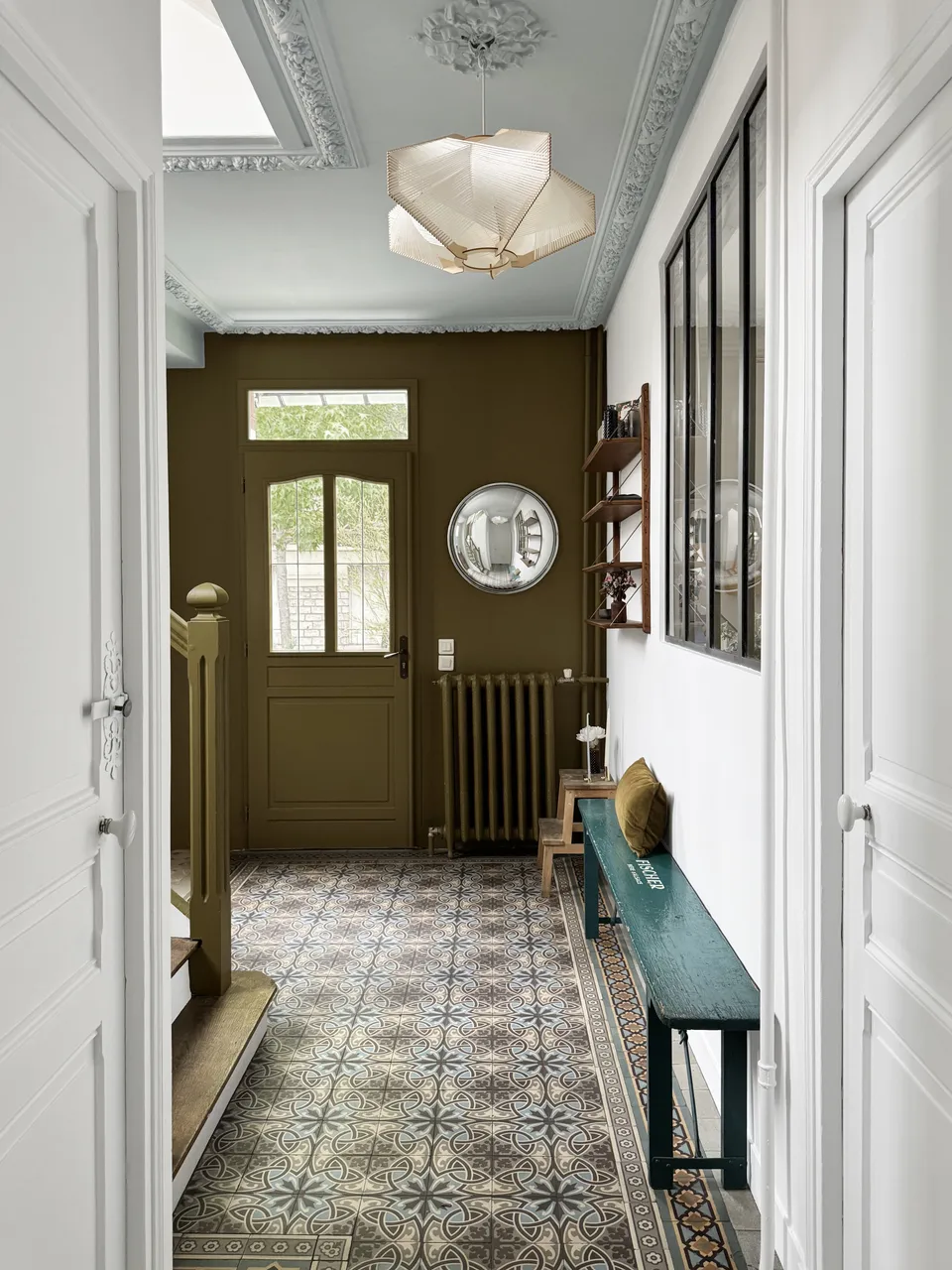 Studio Madame : architecte d’intérieur, Paris et Enghien-les-Bains.
Projet réalisé à Deuil-la-Barre.
Photographie d’intérieur : entrée d'une ancienne meulière rénovée à Deuil-la-Barre avec escalier ancien, moulures, plafond sculpté et niche bleu pâle, banc ancien, porte d’entrée vert bronze et carreaux de ciment d’origine au sol.