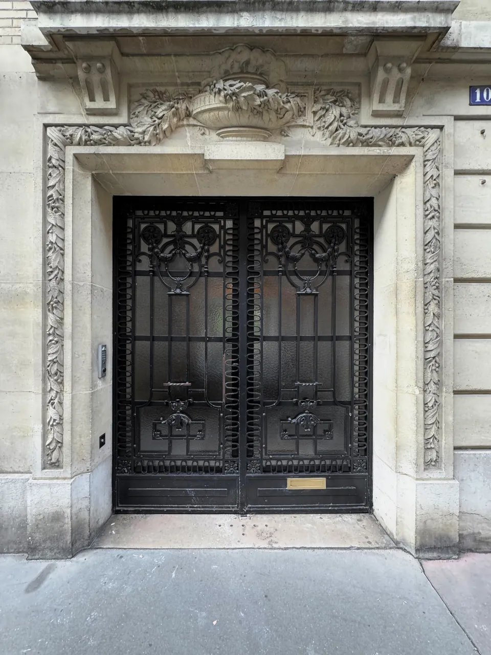 Studio Madame : architecte d’intérieur, Paris et Enghien-les-Bains.
Projet réalisé à Paris.
Photographie d’intérieur : façade d'un immeuble haussmannien à Paris 12, avec pierre de taille sculptée et portes vitrées en métal noir.