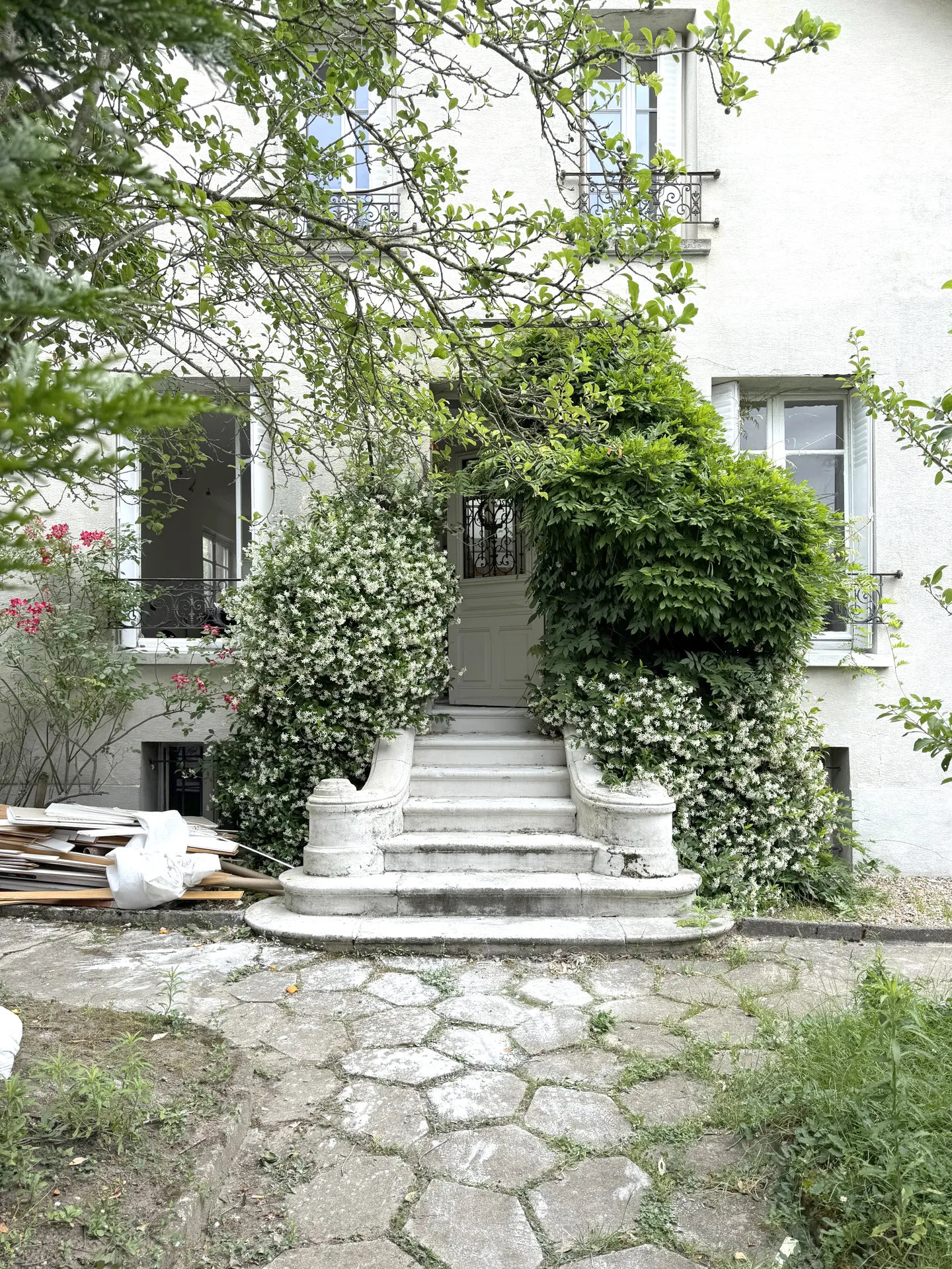 Studio Madame : architecte d’intérieur, Paris et Enghien-les-Bains.
Projet réalisé à Eaubonne.
Photographie d’intérieur : façade d'une maison de ville rénovée à Eaubonne, recouverte de verdure avec perron sculpté.