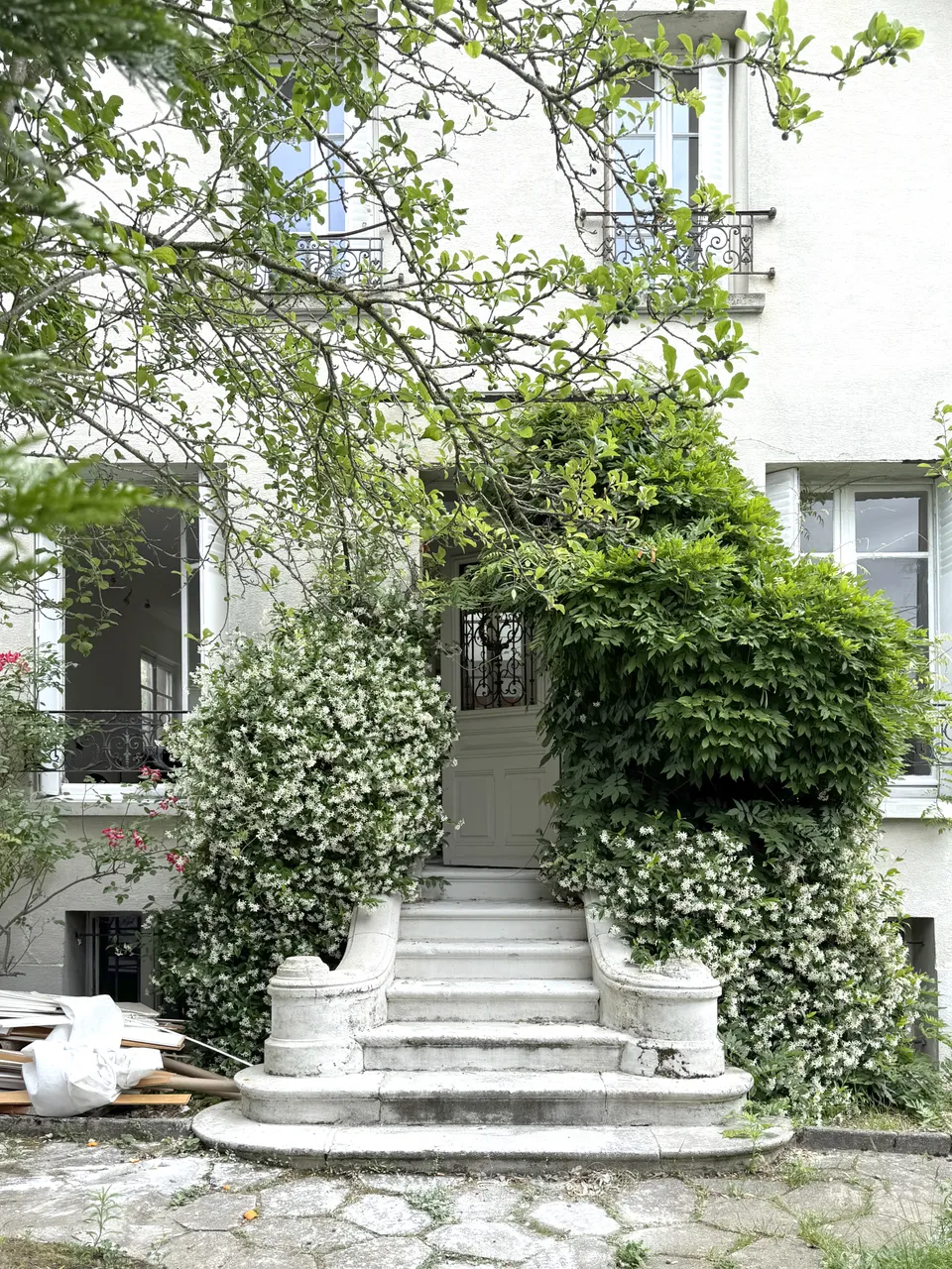 Studio Madame : architecte d’intérieur, Paris et Enghien-les-Bains.
Projet réalisé à Eaubonne.
Photographie d’intérieur : façade d'une maison de ville rénovée à Eaubonne, recouverte de verdure avec perron sculpté.