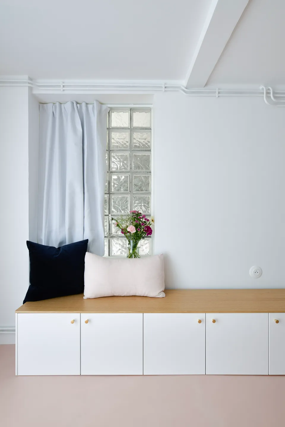 Studio Madame : architecte d’intérieur, Paris et Montmorency.
Projet réalisé à Deuil-la-Barre.
Photographie d’intérieur : banquette blanche réalisée sur mesure (Plum Living) agrémentée d’un plateau chêne, de poignées dorées et de deux coussins bleu nuit et rose poudré. Les murs sont peints en blanc (Ressource) et le sol est habillé d’un béton ciré rose (Harmony Béton).