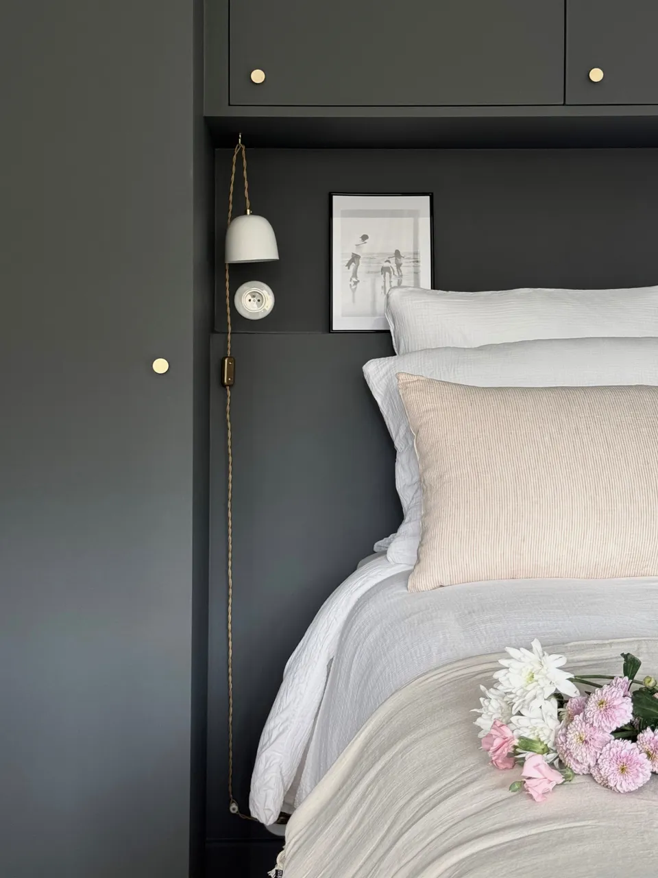 Studio Madame : architecte d’intérieur, Paris et Montmorency
Projet réalisé à Montmorency.
Photographie d’intérieur : chambre parentale avec dressing réalisé sur mesure.
Le dressing est peint dans un gris-vert foncé (Down Pipe - F&B).
Le lit est habillé d’une parure blanche en gaze de coton, de coussins et édredon beiges.
La prise ainsi que les baladeuses sont en porcelaine.
Des fleurs sont posées sur le lit.