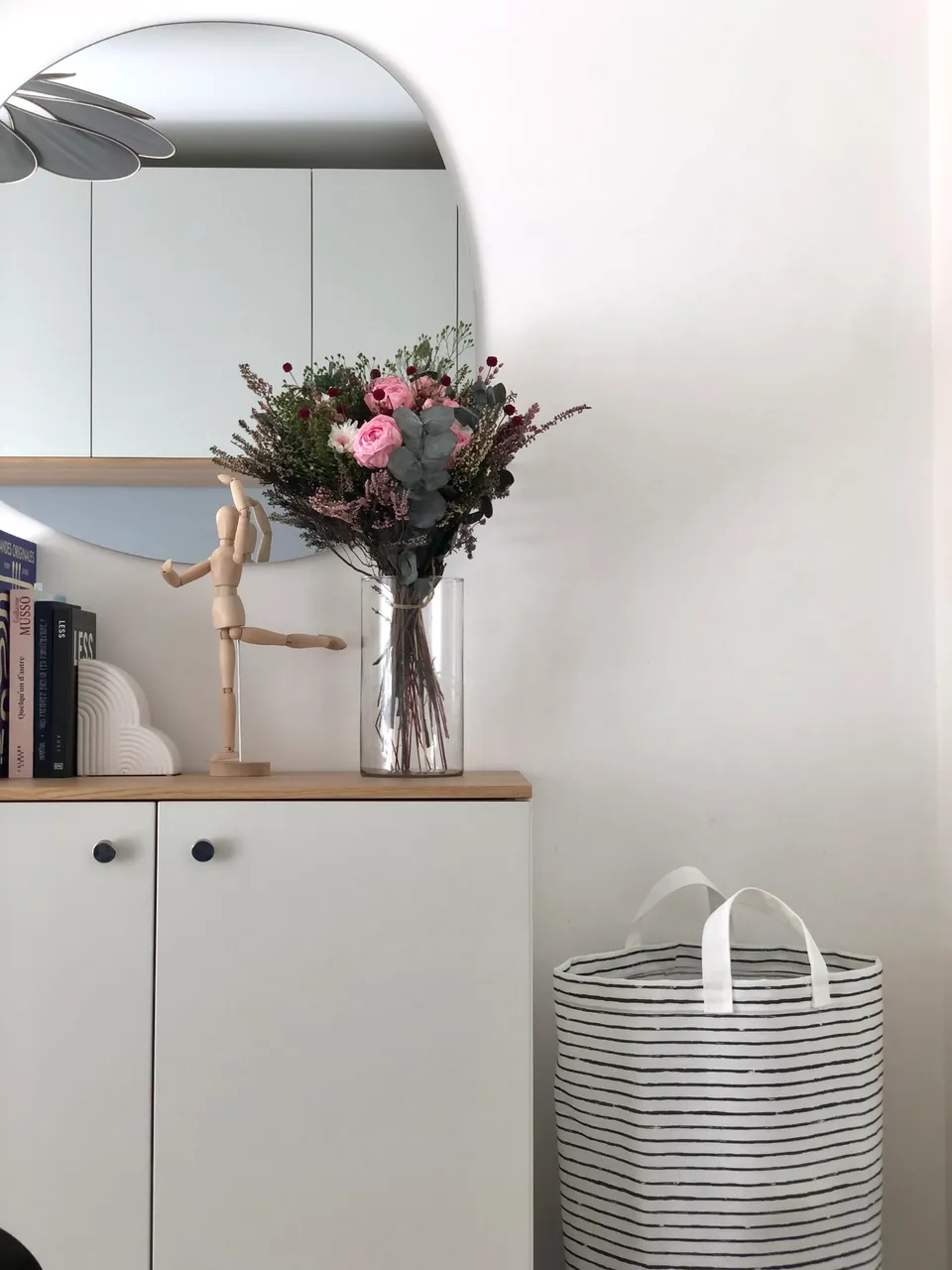 Studio Madame : architecte d’intérieur, Paris et Montmorency
Projet réalisé à Montmorency.
Photographie d’intérieur : chambre parentale (vue sur meuble avec miroir) composée de nuances douces (blanc, gris clair, beige) avec dressing sur mesure en pont de lit. Un bouquet de fleurs dans des tons de rose et violet ainsi que des livres reposent sur ce meuble.