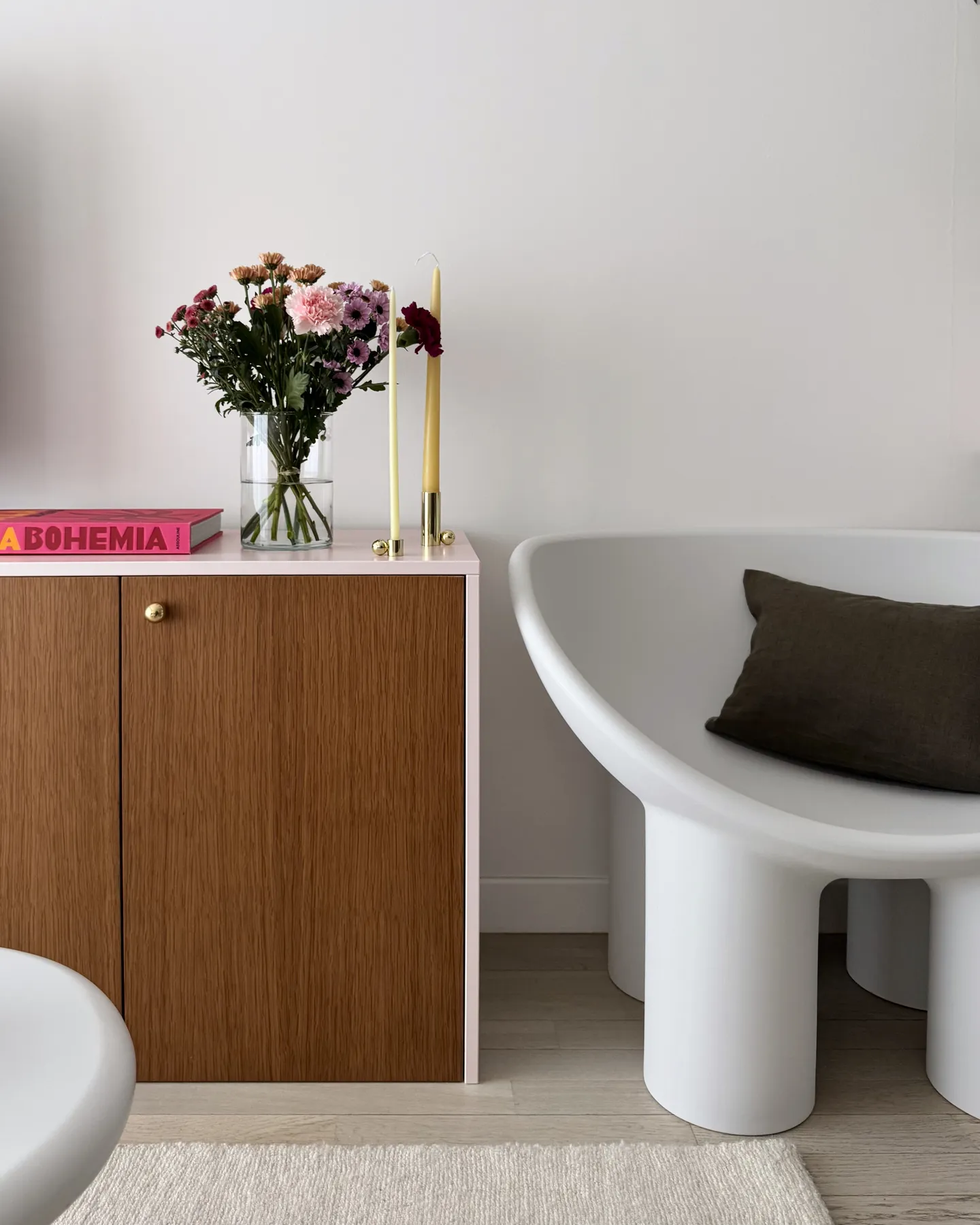 Studio Madame : architecte d’intérieur, Paris et Montmorency
Projet réalisé à Montmorency.
Photographie d’intérieur : salon composé d’un canapé rose, d’une lampe sur pied de couleur bordeaux, d’une petite table d’appoint en travertin sur laquelle reposent un bouquet de fleurs et un magazine de décoration.