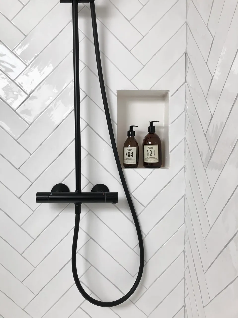 Studio Madame : architecte d’intérieur, Paris et Montmorency
Projet réalisé à Saint-Gratien.
Photographie d’intérieur : salle de bain sous pente avec douche composée d’une faïence blanche artisanale pour la crédence (pose en chevron), robinetterie noire et niche rectangle.