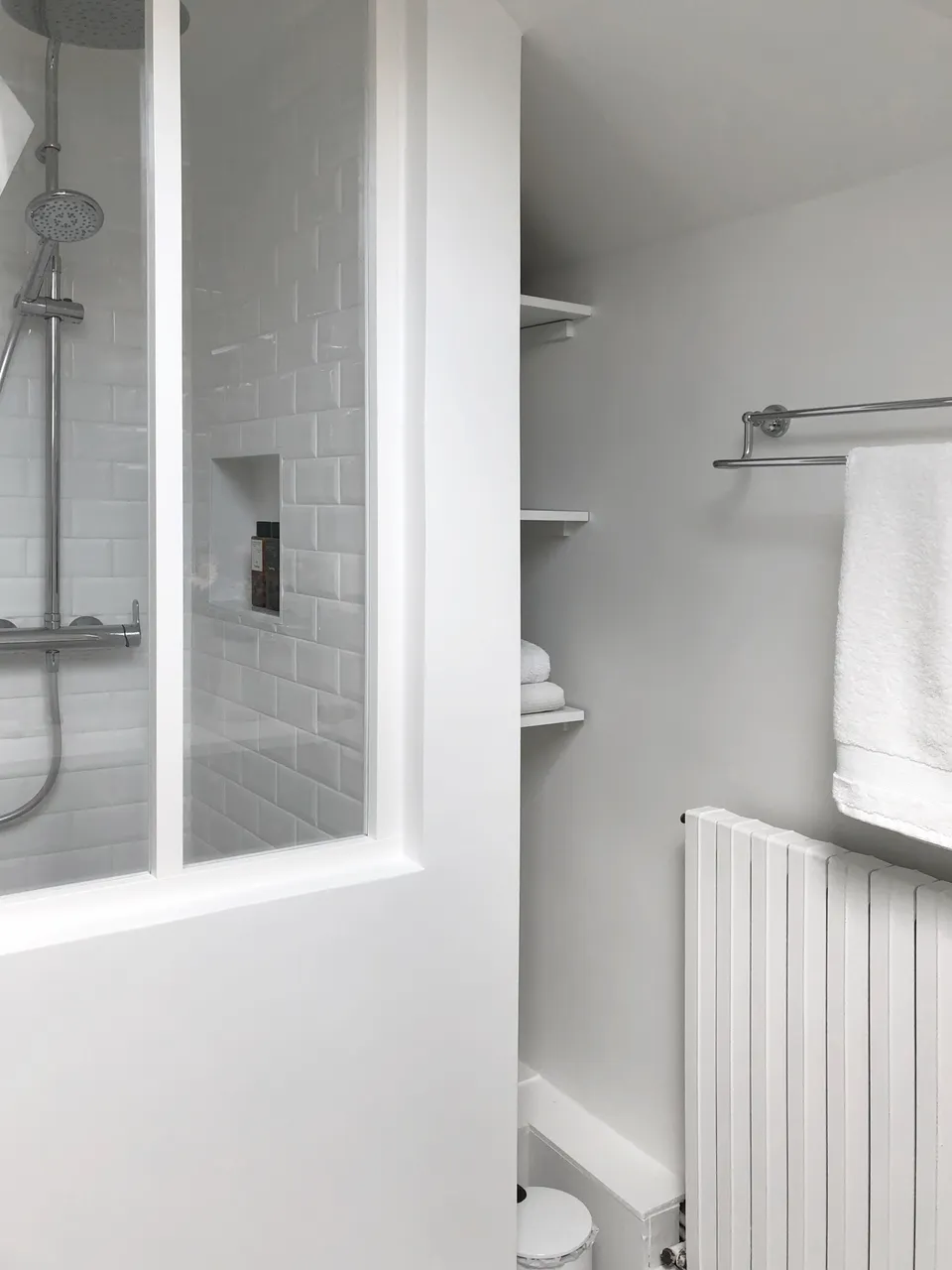 Studio Madame : architecte d’intérieur, Paris et Montmorency
Projet réalisé à Cormeilles-en-Parisis.
Photographie d’intérieur : salle de bain avec douche séparée par une verrière blanche, carreaux de métro en faïence, étagères nichées dans un renfoncement et porte-serviettes vintage chromé.
