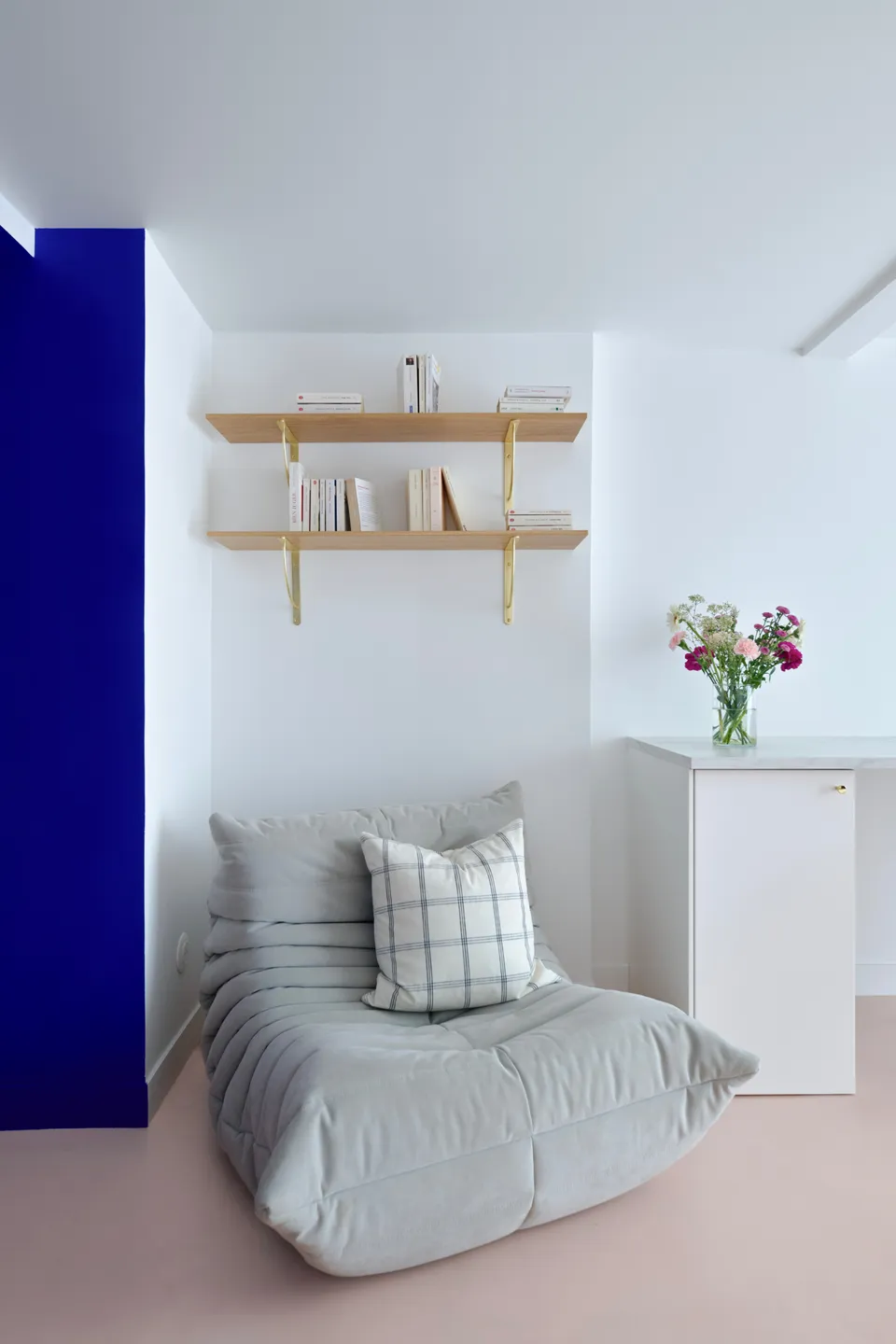 Studio Madame : architecte d’intérieur, Paris et Montmorency.
Projet réalisé à Deuil-la-Barre.
Photographie d’intérieur : arche peinte en bleu Klein (Ressource) amenant sur un bureau blanc réalisé sur mesure (Plum Living) agrémenté d’un plateau marbre, de poignées dorées et d’une chaise minimaliste en bois. Deux étagères chêne montées sur équerres dorées et un fauteuil Togo gris perle (Ligne Roset) forment un petit espace lecture. Les murs sont peints en blanc et bleu Klein (Ressource) et le sol est habillé d’un béton ciré rose (Harmony Béton).