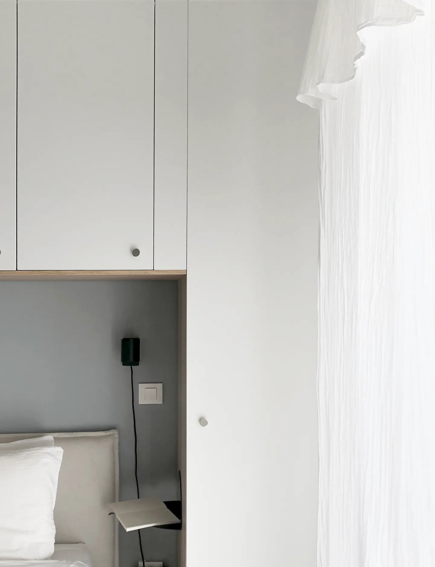 Studio Madame : architecte d’intérieur, Paris et Montmorency
Projet réalisé à Montmorency.
Photographie d’intérieur : chambre parentale composée de nuances douces (blanc, gris clair, beige) avec dressing sur mesure en pont de lit. Des rideaux blancs en gaze de coton habillent les fenêtres.