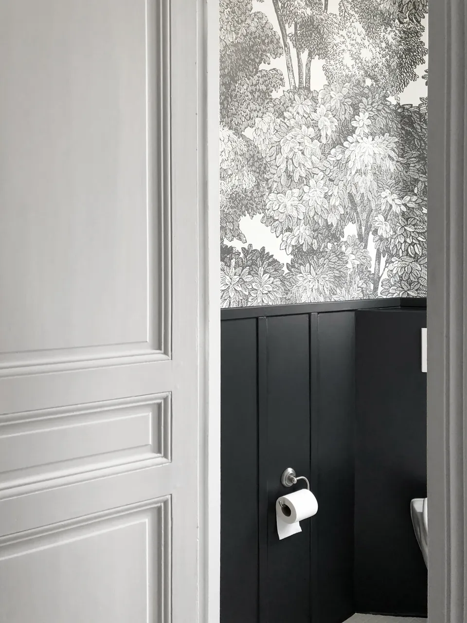 Studio Madame : architecte d’intérieur, Paris et Montmorency
Projet réalisé à Cormeilles-en-Parisis.
Photographie d’intérieur : Cabinet (wc) avec soubassement et moulures gris-bleu nuit, papier peint type fresque gris et blanc et porte ancienne.
