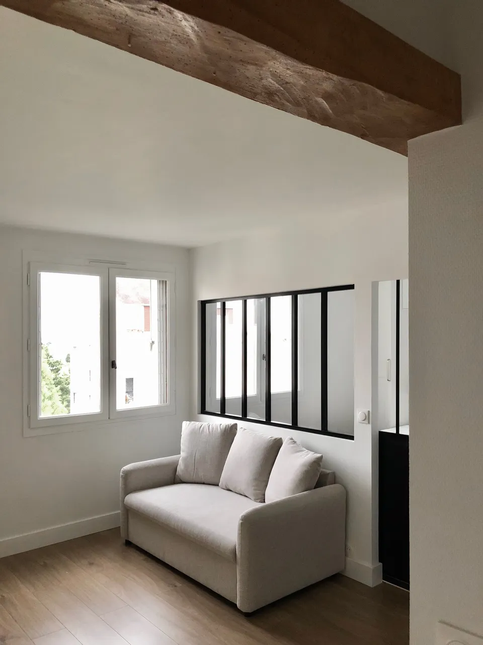 Studio Madame : architecte d’intérieur, Paris et Montmorency
Projet réalisé à Deuil-la-Barre.
Photographie d’intérieur : salon séparé d’une chambre parentale par une verrière atelier noire.
Le salon se compose de murs peints en blanc, d’un parquet en chêne et d’un canapé gris clair.